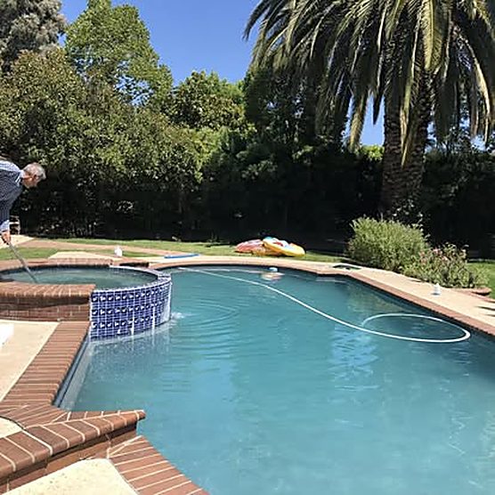 Clear blue rectangular pool with fountain feature after ASJEM Pools cleaning
